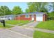 Exterior shot of red brick ranch-style house with a tidy lawn on a sunny day at 412 S Norfolk St, Indianapolis, IN 46241