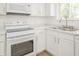 The kitchen offers modern white appliances, a stainless steel sink, and quartz countertops at 412 S Norfolk St, Indianapolis, IN 46241