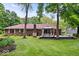 View of the rear brick home exterior, with a charming wooden deck and gazebo for entertaining amidst a well-maintained lawn at 434 Verwood Ct, Indianapolis, IN 46234