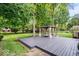 A backyard features a gray wooden deck and a gazebo sitting amongst lush greenery, perfect for outdoor living at 434 Verwood Ct, Indianapolis, IN 46234