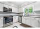 Well-lit kitchen featuring stainless steel appliances, white cabinetry, and tile flooring at 434 Verwood Ct, Indianapolis, IN 46234
