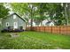 Green backyard with wood fence, stepping stones and mature trees at 4414 Winthrop Ave, Indianapolis, IN 46205