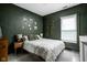 A cozy bedroom showcases dark green walls complemented by soft lighting and a comfortable bed at 4414 Winthrop Ave, Indianapolis, IN 46205