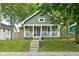 Charming home featuring a cozy front porch, inviting curb appeal, and lovely landscaping at 4414 Winthrop Ave, Indianapolis, IN 46205