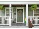 Close-up of a charming front porch with potted plants and a decorated front door at 4414 Winthrop Ave, Indianapolis, IN 46205