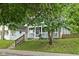 Charming home featuring a front porch, green lawn, and lush trees at 4414 Winthrop Ave, Indianapolis, IN 46205