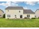 Exterior rear shot of a home featuring a patio set, grill, and lush green grass at 4434 W Windsong Ct, New Palestine, IN 46163