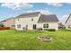 A well-maintained backyard featuring a fire pit, patio furniture, grill, and lush green grass at 4434 W Windsong Ct, New Palestine, IN 46163