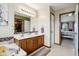 Bright bathroom with a double vanity, a large mirror and an open door to the bedroom at 4434 W Windsong Ct, New Palestine, IN 46163