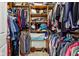 Walk-in closet featuring built-in shelving filled with clothing, shoes, and other accessories at 4434 W Windsong Ct, New Palestine, IN 46163