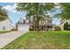 Beautiful home with a lush green lawn and mature trees, showcasing curb appeal at 4434 W Windsong Ct, New Palestine, IN 46163