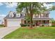 Charming two-story home featuring a spacious front porch, red shutters, and a well-manicured lawn at 4434 W Windsong Ct, New Palestine, IN 46163