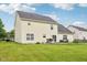 The back exterior of a two-story house featuring a patio, grill, and spacious backyard at 4434 W Windsong Ct, New Palestine, IN 46163