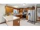 Well-lit kitchen features wood cabinets, stainless steel appliances, an island, and mosaic backsplash at 4434 W Windsong Ct, New Palestine, IN 46163