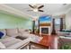 Cozy living room with fireplace, ceiling fan, hardwood floors, and comfortable sofa at 4434 W Windsong Ct, New Palestine, IN 46163