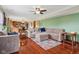 Living room with hardwood floors, comfortable seating, and view into the kitchen at 4434 W Windsong Ct, New Palestine, IN 46163