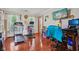 Bright room featuring hardwood floors, workout equipment, and a large television at 4434 W Windsong Ct, New Palestine, IN 46163