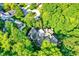 Stunning aerial view of a home nestled among mature trees, with a circular driveway and lush green surroundings at 4530 Chase Oak Ct, Zionsville, IN 46077