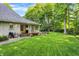 A lush backyard features a covered porch and a stone patio with a grill at 4530 Chase Oak Ct, Zionsville, IN 46077