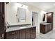Stylish bathroom featuring dark cabinetry, dual sinks, and a soaking tub in mirror's reflection at 4530 Chase Oak Ct, Zionsville, IN 46077