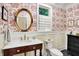 Powder room with floral wallpaper, dark wood vanity, and black tile flooring at 4530 Chase Oak Ct, Zionsville, IN 46077