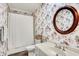 Quaint bathroom featuring floral wallpaper, decorative mirror, and classic fixtures at 4530 Chase Oak Ct, Zionsville, IN 46077