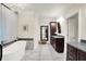 Luxurious bathroom featuring tiled floors, dark cabinets, soaking tub, and modern fixtures at 4530 Chase Oak Ct, Zionsville, IN 46077