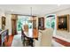 Elegant dining room with large table, chandelier, hardwood floors, and views through large windows at 4530 Chase Oak Ct, Zionsville, IN 46077