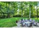 Fire pit with Adirondack chairs in the backyard on stone patio at 4530 Chase Oak Ct, Zionsville, IN 46077