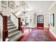 Elegant foyer with hardwood floors, staircase, chandelier, and view into the dining room at 4530 Chase Oak Ct, Zionsville, IN 46077