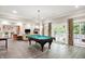 Spacious game room featuring a billiard table, hardwood floors, and large windows for natural lighting at 4530 Chase Oak Ct, Zionsville, IN 46077