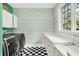 Bright laundry room with checkerboard floors, white cabinets, and a window view at 4530 Chase Oak Ct, Zionsville, IN 46077