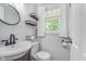 Stylish half bath with a modern sink, sleek mirror, and natural light from the window at 4840 E 77Th St, Indianapolis, IN 46250