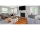 Open living room with a decorative fireplace, hardwood floors, and large windows at 4840 E 77Th St, Indianapolis, IN 46250
