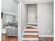 Bright stairway featuring hardwood steps and a view into the cozy living room at 4840 E 77Th St, Indianapolis, IN 46250