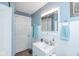 This bathroom features a white vanity, blue walls, and a gray wood floor at 4922 Brookville Rd, Indianapolis, IN 46201