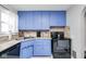 Charming kitchen featuring blue cabinetry, modern appliances, and tiled backsplash at 4922 Brookville Rd, Indianapolis, IN 46201