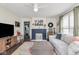 Bright living room with a brick fireplace, plush seating, and hardwood floors at 4922 Brookville Rd, Indianapolis, IN 46201