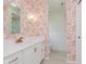 Updated bathroom featuring a modern vanity, gold hardware, and decorative wallpaper at 5982 Melbourne Rd, Indianapolis, IN 46228