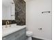 Half bathroom with marble countertop, grey vanity, decorative wallpaper, and black hardware at 5982 Melbourne Rd, Indianapolis, IN 46228