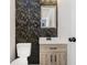 Stylish half bathroom features vanity and decorative wallpaper at 5982 Melbourne Rd, Indianapolis, IN 46228