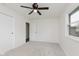 Carpeted bedroom features a ceiling fan, neutral walls and natural light from a window at 5982 Melbourne Rd, Indianapolis, IN 46228