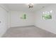 Bright, vacant bedroom with neutral carpet, closet, and backyard views at 5982 Melbourne Rd, Indianapolis, IN 46228