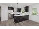 Modern kitchen with black cabinetry, stainless steel appliances, and a white countertop island at 5982 Melbourne Rd, Indianapolis, IN 46228