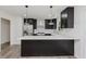 Modern kitchen with dark cabinets, stainless steel appliances, and a white countertop island at 5982 Melbourne Rd, Indianapolis, IN 46228