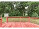 A backyard showcases a vibrant green lawn, mature trees, and a well-maintained wooden deck for outdoor enjoyment at 6010 Rocky River Dr, Indianapolis, IN 46221