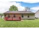Backyard view of home with red deck and partial fencing at 6010 Rocky River Dr, Indianapolis, IN 46221