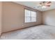 Well-lit bedroom featuring neutral walls and carpeting, a ceiling fan, and a bright window at 6010 Rocky River Dr, Indianapolis, IN 46221