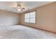Bright bedroom showcasing neutral walls and carpeting, a ceiling fan, and a large window at 6010 Rocky River Dr, Indianapolis, IN 46221
