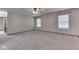 Spacious bedroom features plush carpeting, a ceiling fan, and bright natural light from two large windows at 6010 Rocky River Dr, Indianapolis, IN 46221